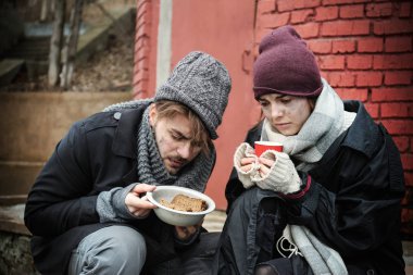 Kirli sokakta ekmek ile zavallı genç çift