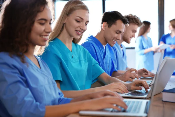 Grupo de estudiantes de medicina inteligentes con aparatos en la universidad — Foto de Stock