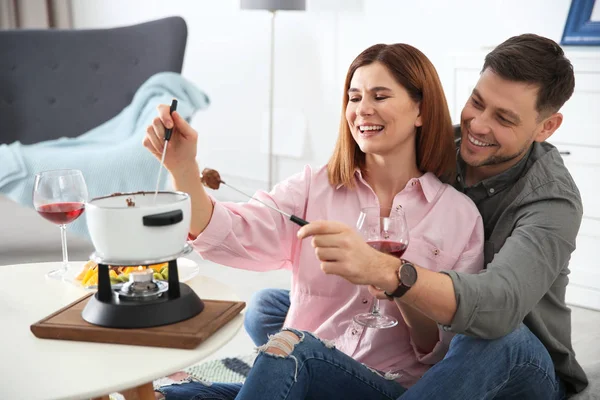 Pareja feliz disfrutando de la cena fondue en casa — Foto de Stock