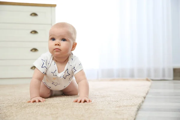 Cute little baby crawling on carpet indoors, space for text
