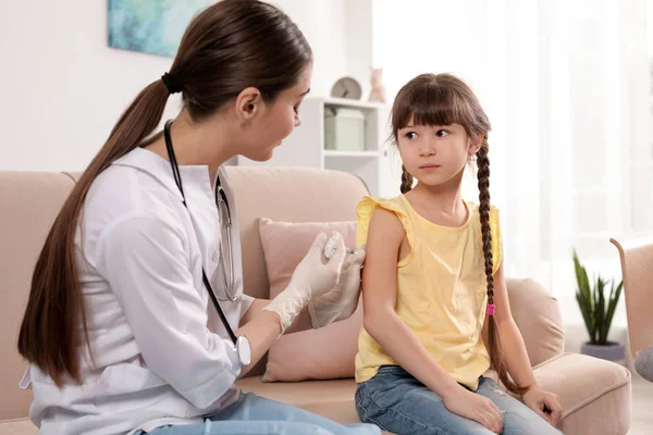 Médico de familia vacunando a un niño pequeño en casa — Foto de Stock