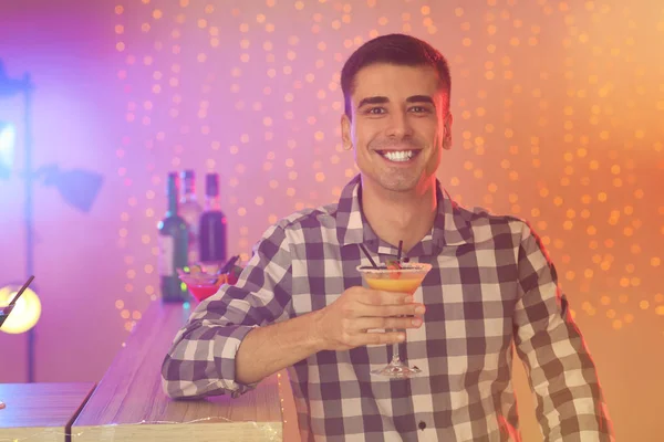 Jongeman met glas martini cocktail op feest — Stockfoto