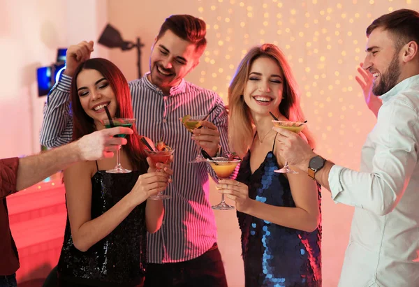 Partide martini kokteyli tutan bir grup genç