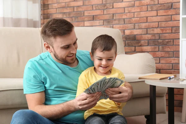 Gelukkige vader en zoon met geld thuis — Stockfoto