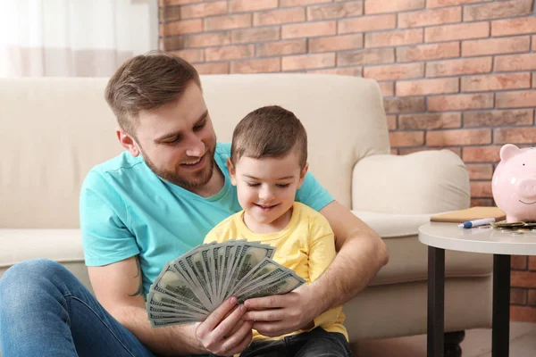 Šťastný otec a syn s penězi doma — Stock fotografie