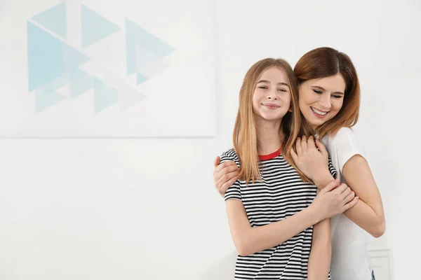 Счастливая мать обнимает свою дочь-подростка дома — стоковое фото