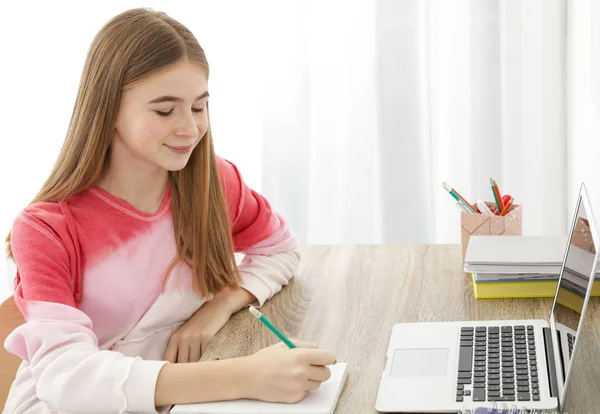 Teenagerka dělá úkoly u stolu — Stock fotografie