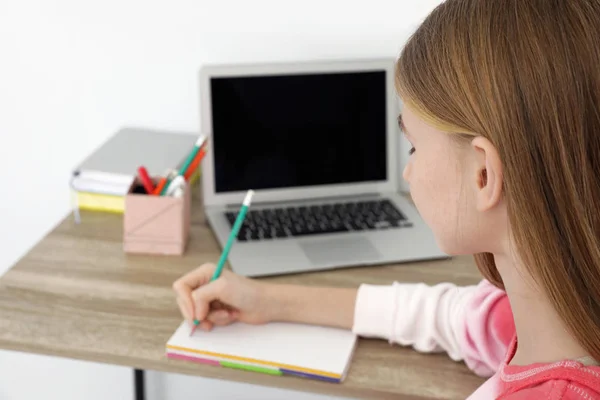 Adolescente chica haciendo su tarea en el escritorio — Foto de Stock