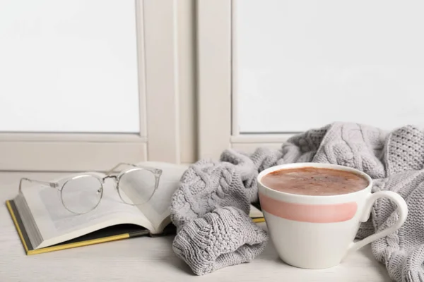 Samenstelling met kopje warme chocolademelk en boek op vensterbank, ruimte voor tekst. Winter drankje — Stockfoto