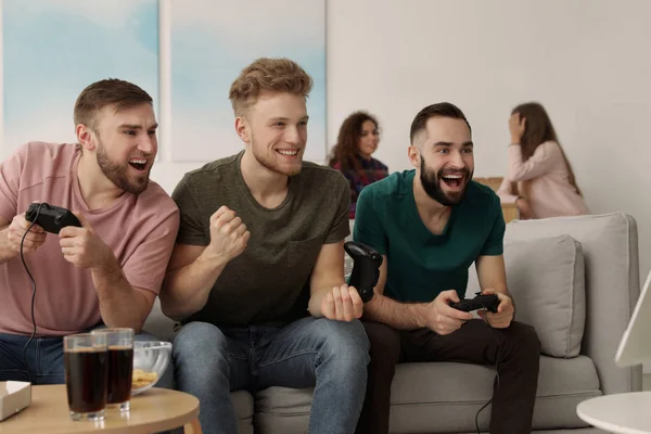 Emotional friends playing video games at home