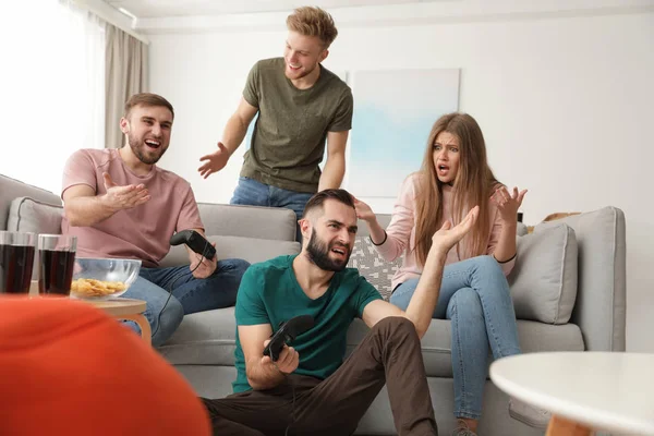 Amigos emocionais jogando videogames em casa — Fotografia de Stock