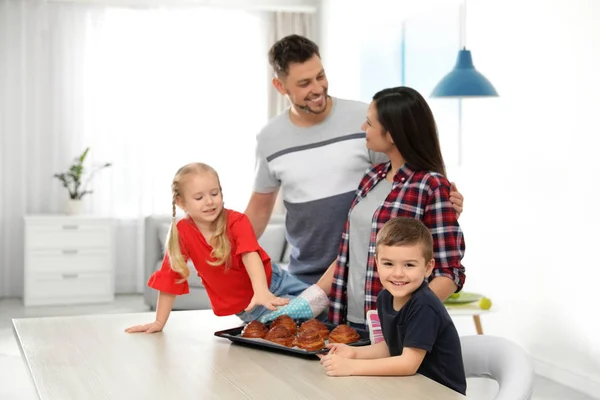 Lycklig familj med bricka med ugnsbakade bullar i köket — Stockfoto