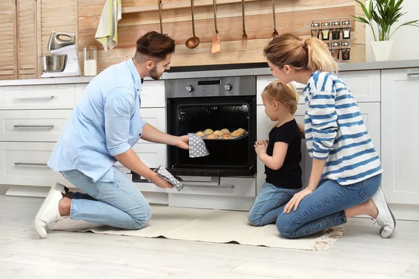 Feliz família assar biscoitos no forno em casa — Fotografia de Stock