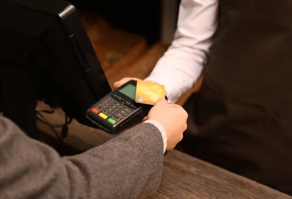 Mujer con tarjeta de crédito usando terminal de pago en tienda, primer plano — Foto de Stock