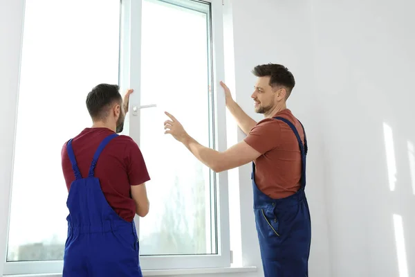 Byggnadsarbetare installerar plast fönster i hus — Stockfoto