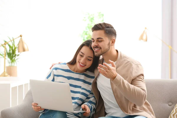 Casal usando laptop para chat de vídeo na sala de estar — Fotografia de Stock
