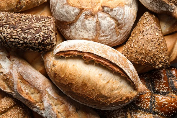 Diferentes tipos de pan fresco como fondo, vista superior — Foto de Stock