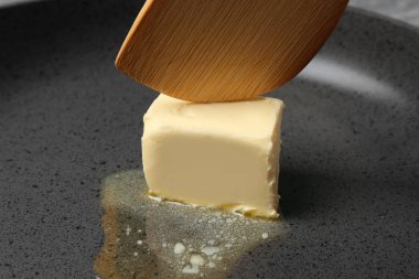 Eriyen tereyağı ve spatula parçası ile kızartma tavası, closeup