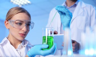 Modern kimya laboratuvarında numune ile çalışan kadın bilim adamı