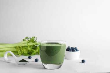 Beyaz arka plan üzerinde spirulina smoothie cam ile Kompozisyon. Metin için alan