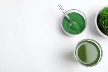 Beyaz arka planda bir bardak spirulina içeceği ile kompozisyon, üst görünüm