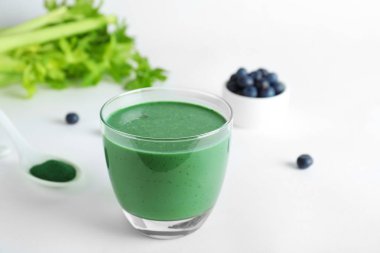 Beyaz arka plan üzerinde spirulina smoothie cam ile Kompozisyon. Metin için alan