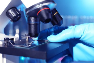 Modern mikroskopla çalışan bilim adamı, yakın çekim. Kimyasal araştırma