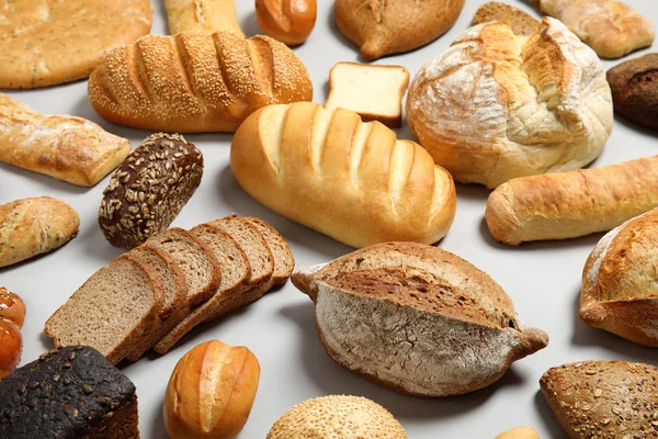 Różne rodzaje świeżego chleba na jasnym tle — Zdjęcie stockowe