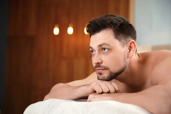 Yakışıklı adam spa salonunda masaj masasında rahatlatıcı. Metin için alan — Stok fotoğraf