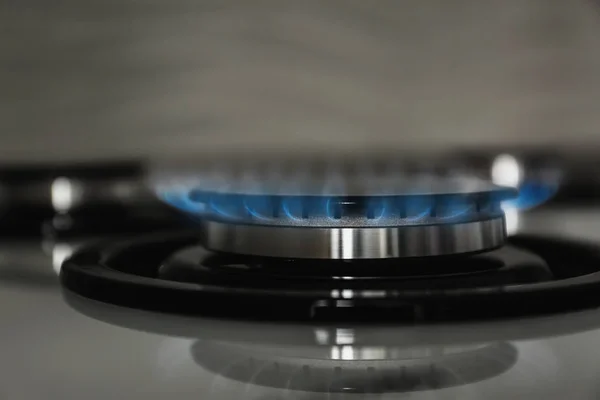 Gas burner with blue flame on modern stove, closeup — Stock Photo, Image