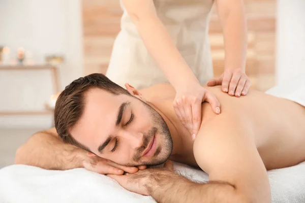 Hombre guapo recibiendo masaje de espalda en el salón de spa — Foto de Stock