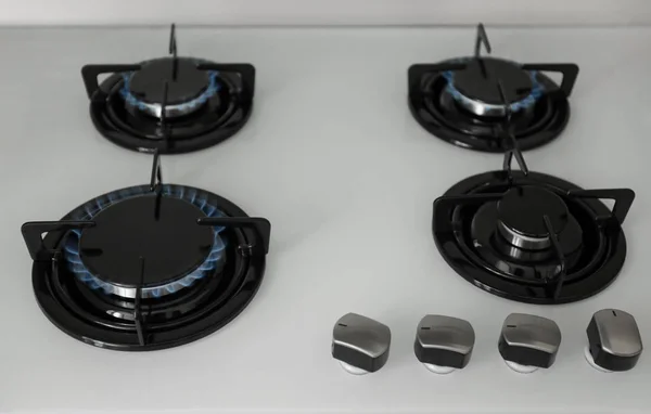 Gas burners with blue flame on modern stove — Stock Photo, Image