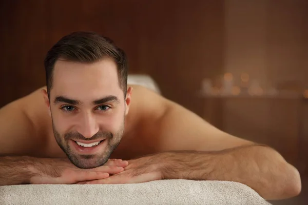 Spa salonunda masaj masasında rahatlatıcı yakışıklı adam — Stok fotoğraf