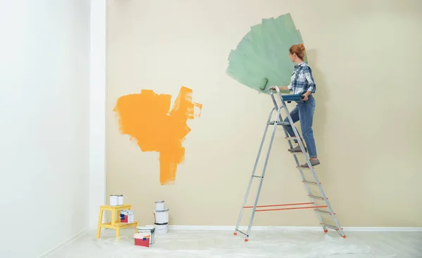 Γυναίκα ζωγραφίζει τοίχους σε εσωτερικούς χώρους, χώρος για κείμενο. Επισκευή — Φωτογραφία Αρχείου