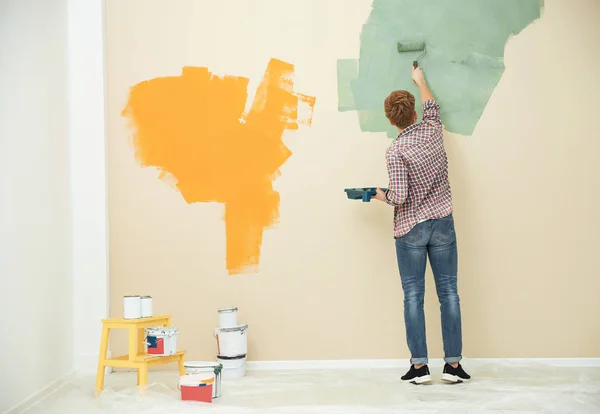 Jovem pintando parede dentro de casa, espaço para texto. Reparação doméstica — Fotografia de Stock