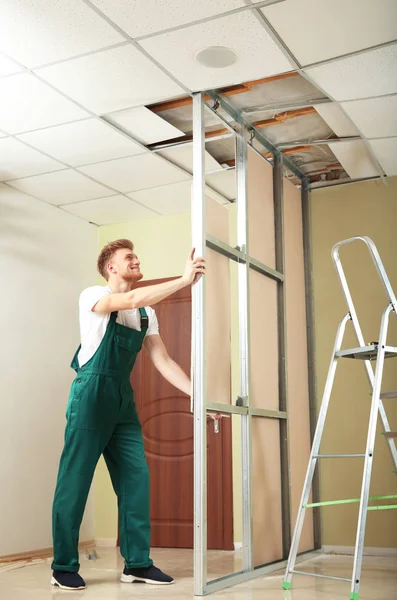 Jovem trabalhador instalando drywall dentro de casa. Serviço de reparação em casa — Fotografia de Stock