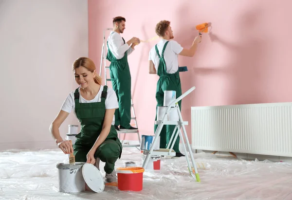 Equipo de decoradores profesionales pintando paredes interiores. Servicio de reparación en el hogar — Foto de Stock