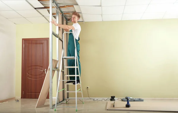 Ung arbetare installerar gipsväggar inomhus. Reparation i hemmet — Stockfoto