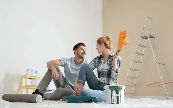 Счастливая пара с планированием покраски дома ремонт в помещении — стоковое фото