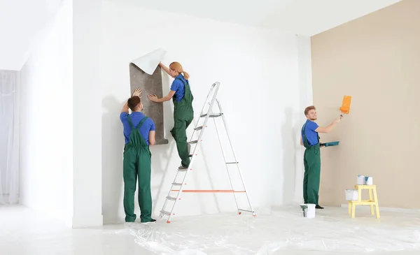 Decoradores profesionales trabajando en interiores. Servicio de reparación en el hogar — Foto de Stock