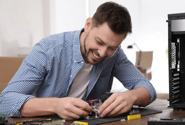 Técnico masculino reparando la placa base en la mesa en el interior —  Fotos de Stock