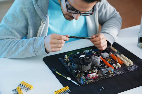 Férfi technikus javítás számítógép alaplap az asztalnál — Stock Fotó