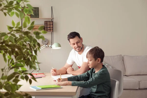 Pappa hjälpte sin son med skoluppgift hemma — Stockfoto