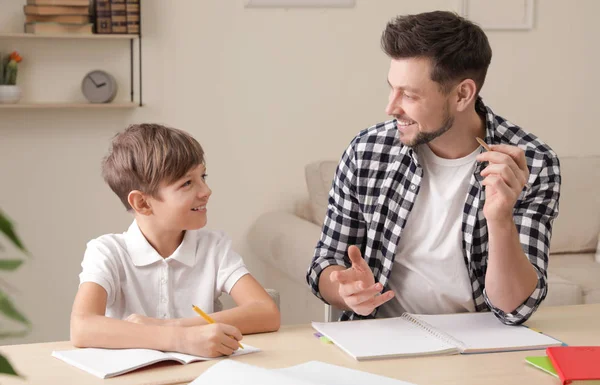 Papá ayudando a su hijo con la tarea escolar en casa — Foto de Stock