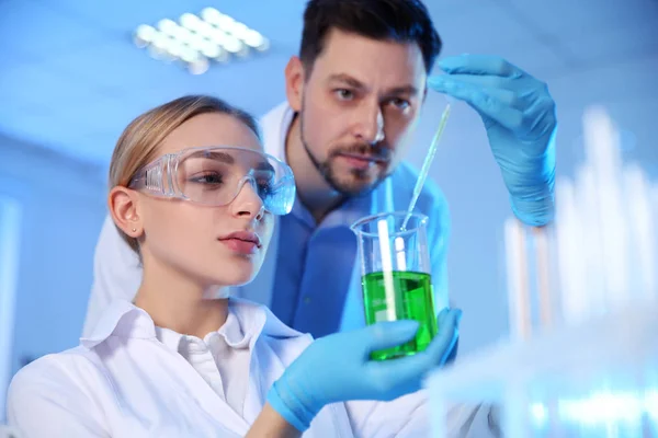 Cientistas trabalhando com amostra em laboratório de química — Fotografia de Stock