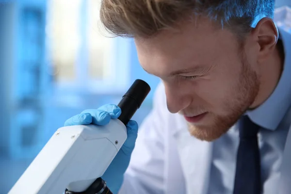 Mužský vědec používající moderní mikroskop v chemické laboratoři — Stock fotografie