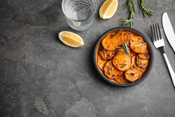 Placa con rodajas de batata horneadas servidas sobre mesa gris, vista superior. Espacio para texto — Foto de Stock