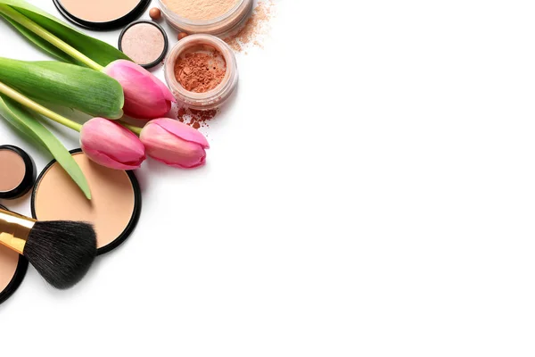 Många olika makeup produkter och vårblommor på vit bakgrund, uppifrån — Stockfoto