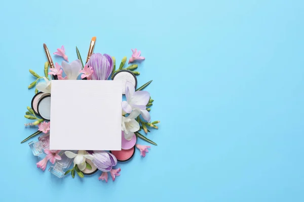 Makeup products, spring flowers and blank card on color background, flat lay. Space for text — Stock Photo, Image