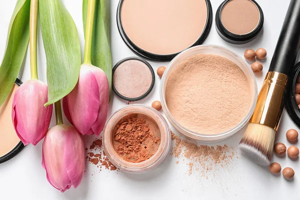 Veel verschillende make-up producten en lente bloemen op witte achtergrond, bovenaanzicht — Stockfoto